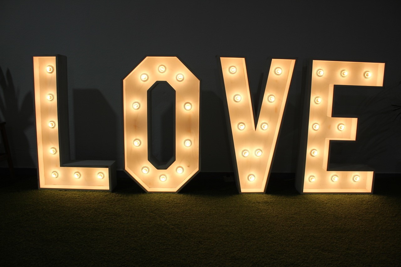Letras de madera iluminadas formando la palabra “LOVE” - Grupo